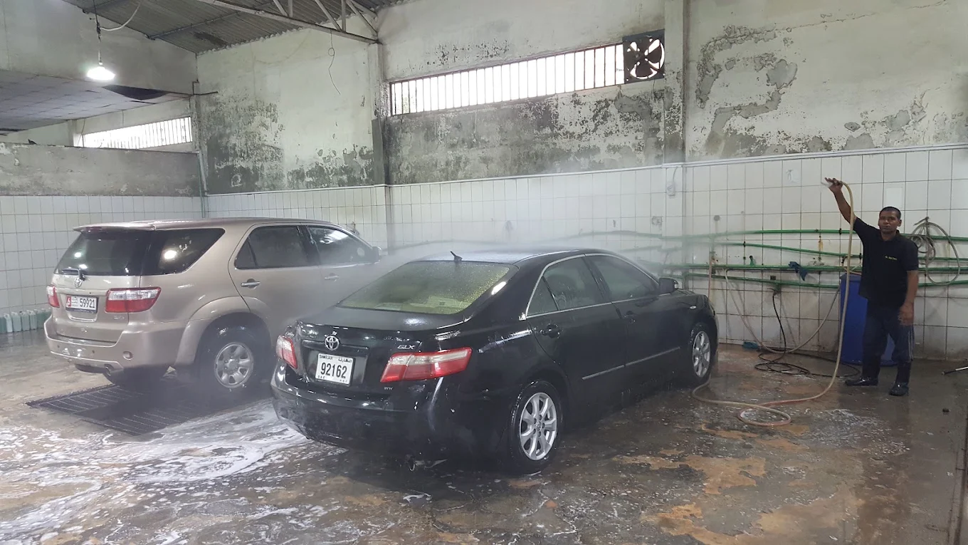 A car being rinsed in a wash bay at Al Batra Cars Washing